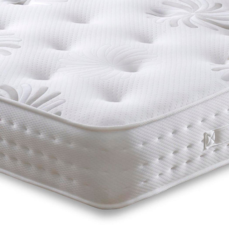 Close-up of a white mattress with a brand logo on a white background