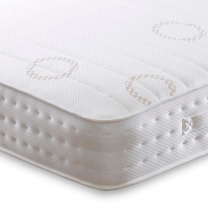 Close-up of a white mattress with textured surface and brand logo on a white background
